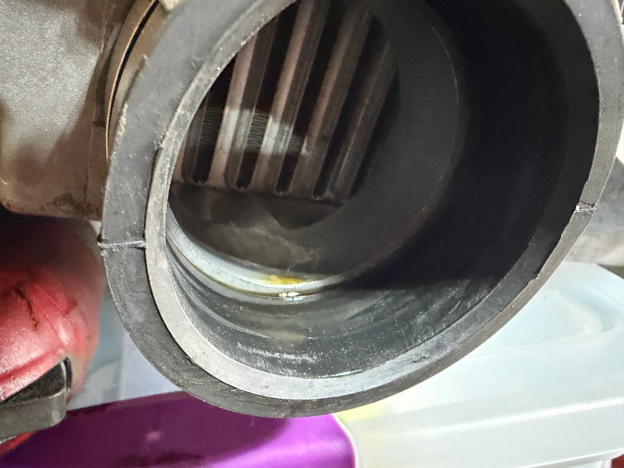 A close-up looking into the end of the intercooler, with a shallow pool of oil sitting in the bottom of it.